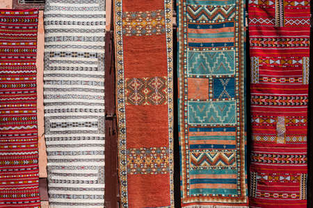 Un-tapis-africain-vibrant-et-coloré-avec-des-motifs-traditionnels-et-géométriques-fabriqué-à-la-main-par-des-artisans-talentueux-posé-sur-un-sol-en-bois-dans-un-intérieur-moderne